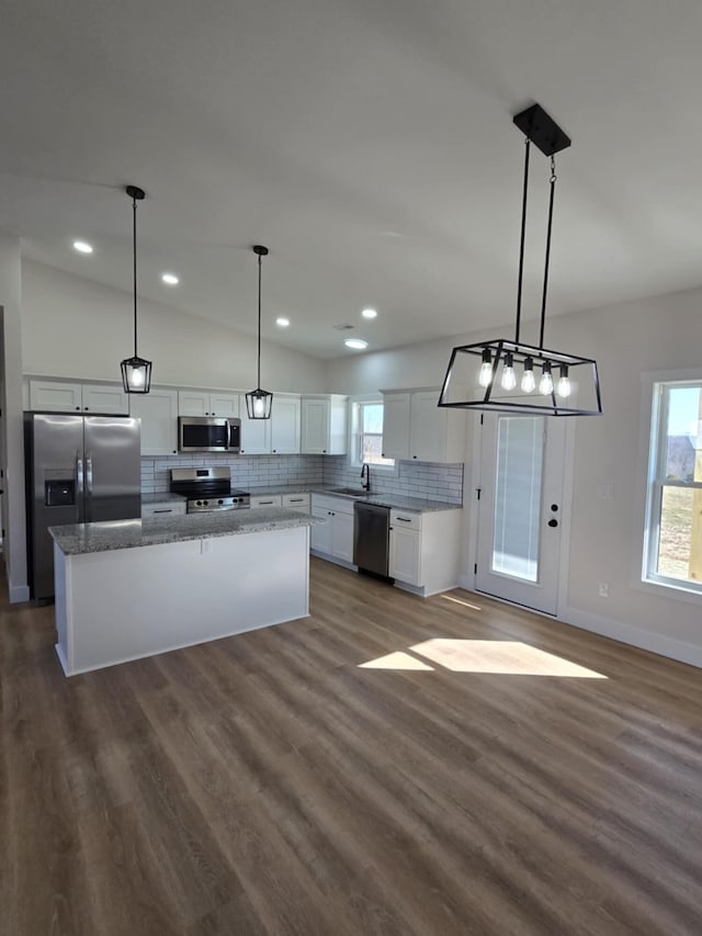 kitchen with sink, white cabinetry, hanging light fixtures, a kitchen island, and stainless steel appliances