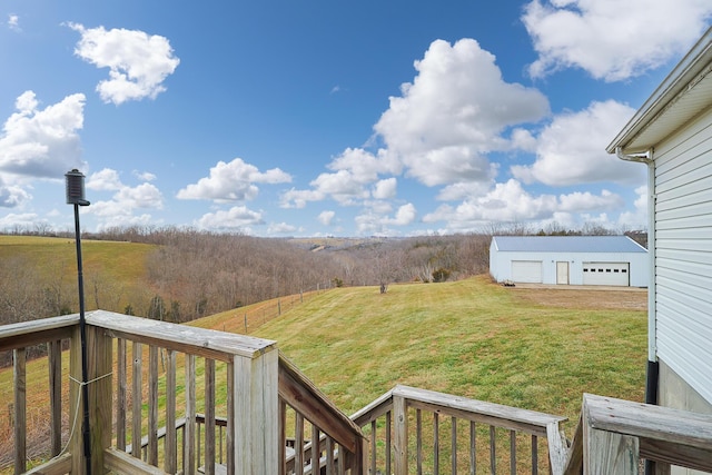 view of yard with an outbuilding, a garage, a deck, and a rural view