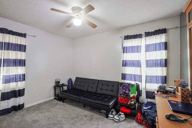 living area with ceiling fan, a textured ceiling, and carpet flooring