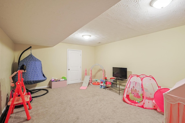 recreation room featuring carpet flooring and a textured ceiling