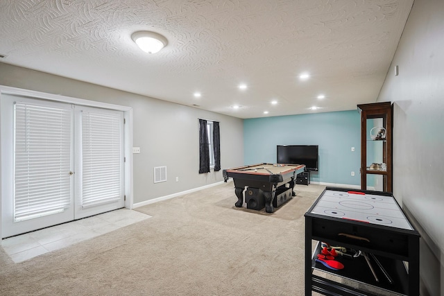 playroom with light colored carpet, a textured ceiling, and pool table