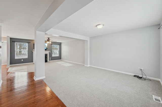 unfurnished living room with ceiling fan and carpet flooring