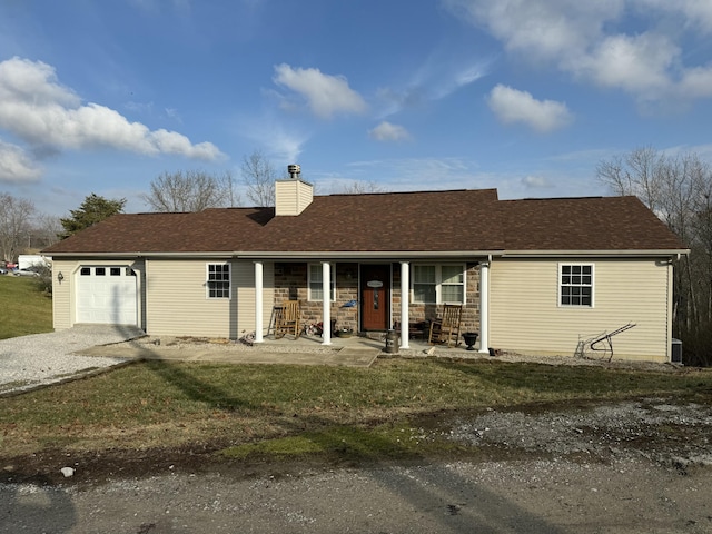 view of front of property featuring a porch, a garage, and a front yard