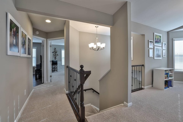 stairs with carpet and a notable chandelier