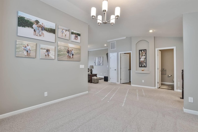 carpeted empty room with vaulted ceiling, crown molding, and a chandelier