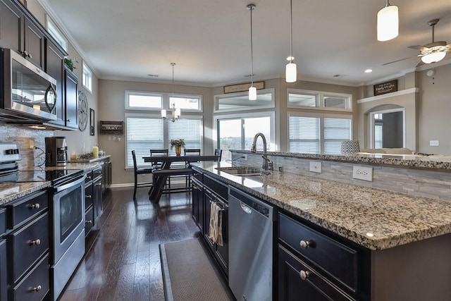 kitchen featuring appliances with stainless steel finishes, sink, a center island with sink, and pendant lighting