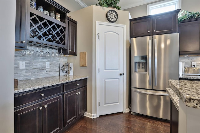 kitchen featuring crown molding, stainless steel fridge, and light stone counters