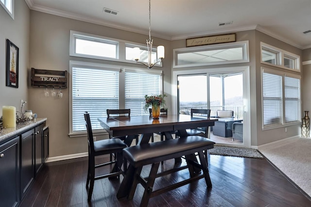 dining area with crown molding, dark hardwood / wood-style flooring, and a notable chandelier