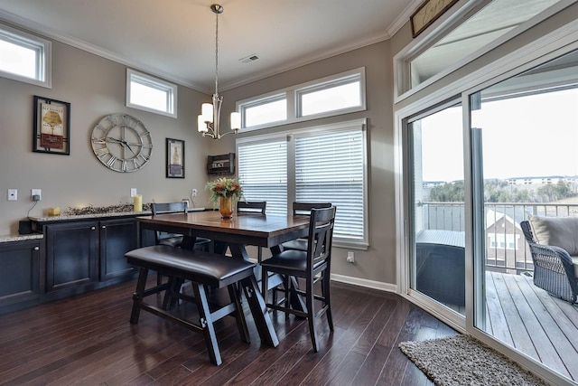 dining area with an inviting chandelier, crown molding, a wealth of natural light, and dark hardwood / wood-style floors