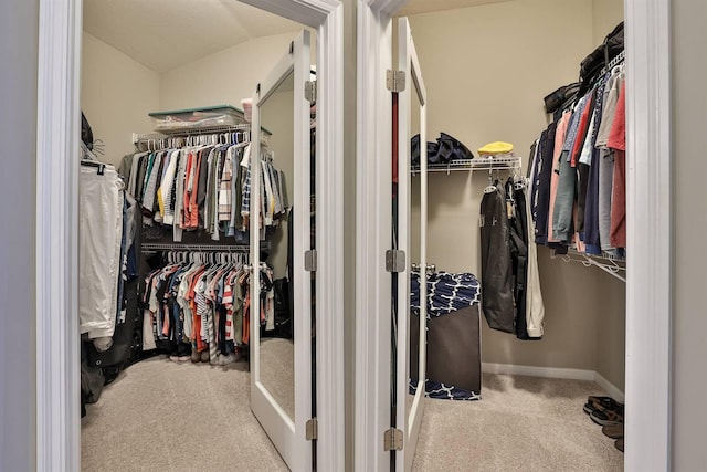 walk in closet with light carpet