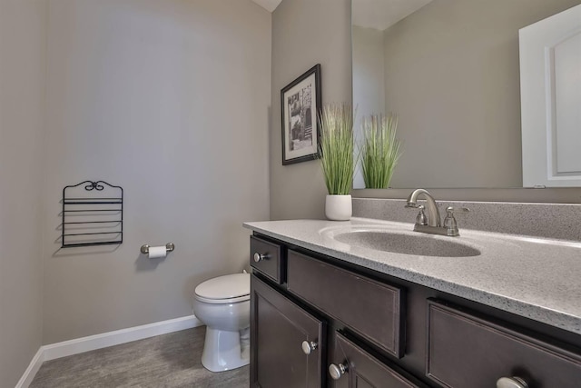 bathroom featuring vanity, hardwood / wood-style floors, and toilet