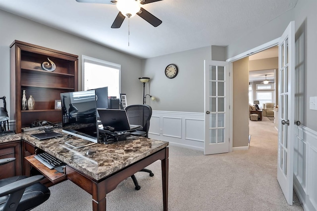 carpeted office space featuring french doors and ceiling fan