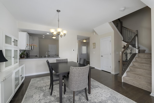 dining room featuring a notable chandelier, sink, and dark hardwood / wood-style floors