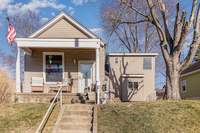 view of front of property featuring covered porch and a front yard