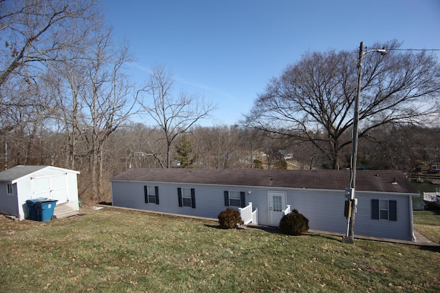 back of property with an outbuilding, a yard, and a shed