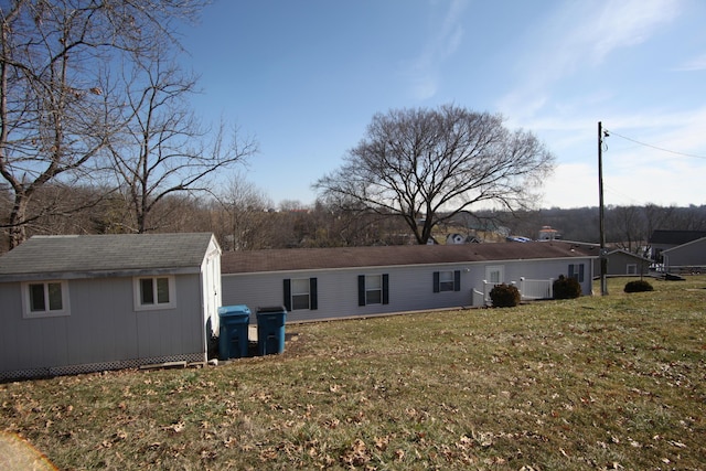 rear view of property with an outdoor structure, a lawn, and a shed