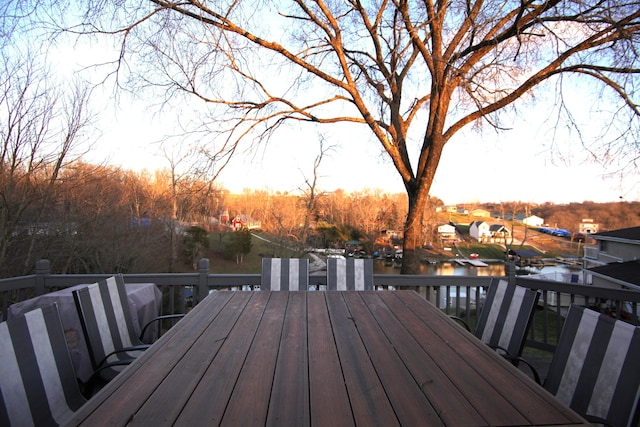 wooden deck with outdoor dining area and a water view