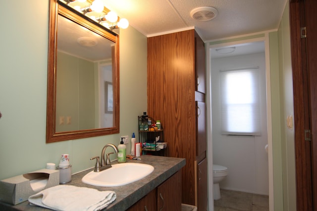 bathroom with toilet, visible vents, and vanity