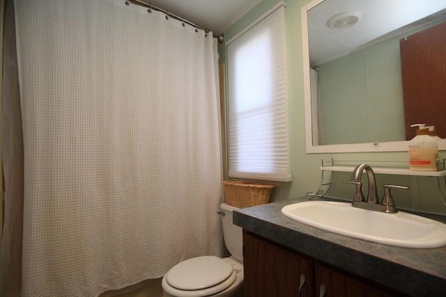 full bathroom featuring a shower with shower curtain, visible vents, vanity, and toilet