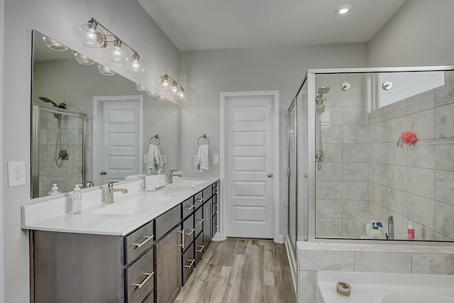 bathroom featuring a sink, a shower stall, and wood finished floors