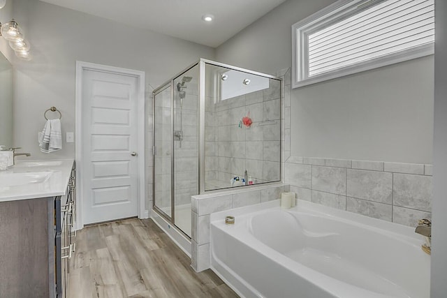 bathroom with wood finished floors, a garden tub, vanity, and a shower stall