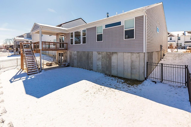 snow covered property with fence and stairs