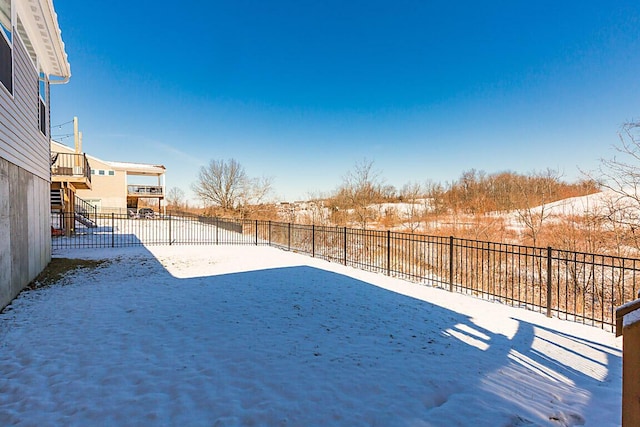 snowy yard with a fenced backyard