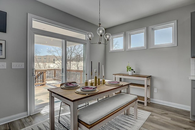 dining space with a healthy amount of sunlight, light wood-style floors, and baseboards