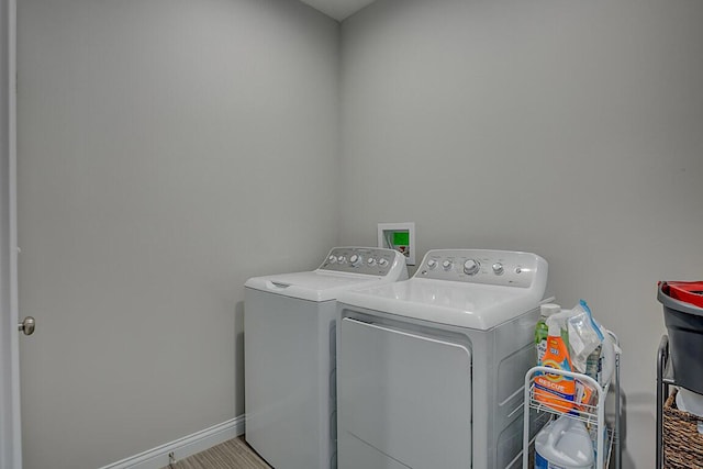 laundry area with laundry area, separate washer and dryer, and baseboards