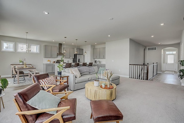 living room with arched walkways, baseboards, visible vents, and recessed lighting