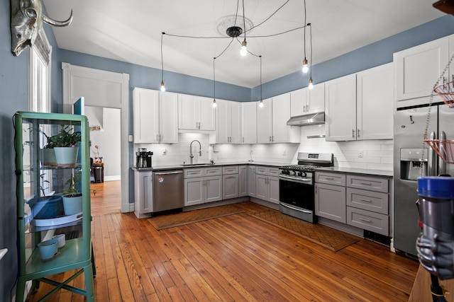 kitchen with gray cabinetry, sink, stainless steel appliances, and white cabinets