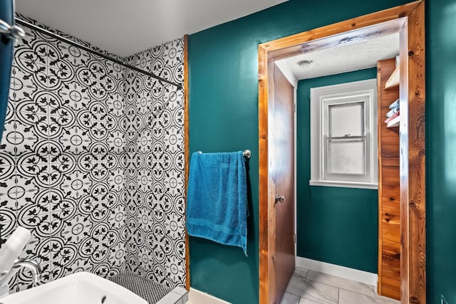 bathroom with tile patterned flooring, a shower, and a textured ceiling