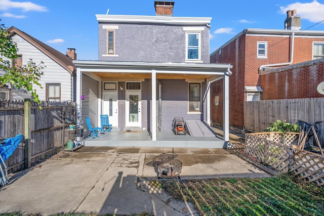 rear view of house featuring covered porch and a patio area