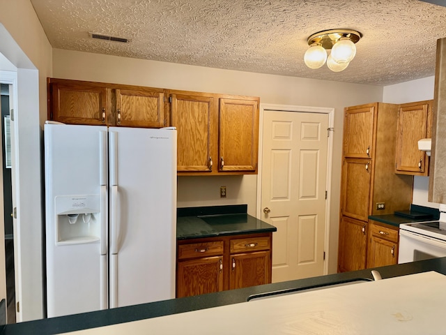 kitchen featuring white appliances and a textured ceiling