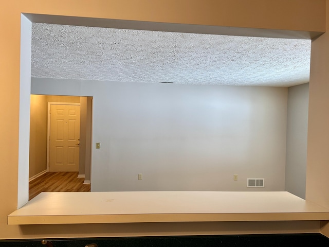 unfurnished room featuring hardwood / wood-style flooring and a textured ceiling