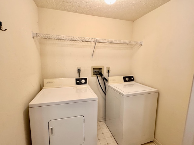 washroom with washer and clothes dryer and a textured ceiling