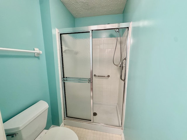 bathroom featuring an enclosed shower, a textured ceiling, and toilet