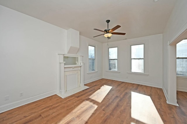 unfurnished living room featuring hardwood / wood-style flooring, a fireplace, and ceiling fan