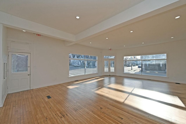 interior space featuring beam ceiling and light hardwood / wood-style flooring