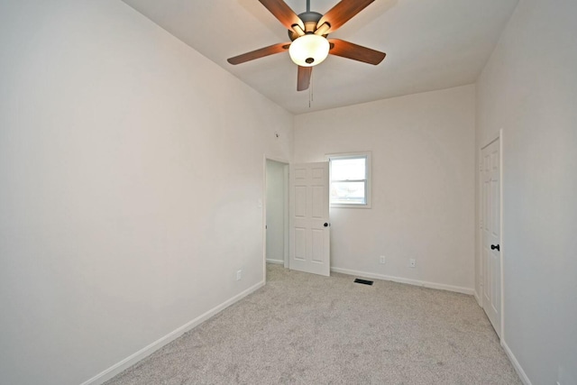 carpeted spare room with ceiling fan