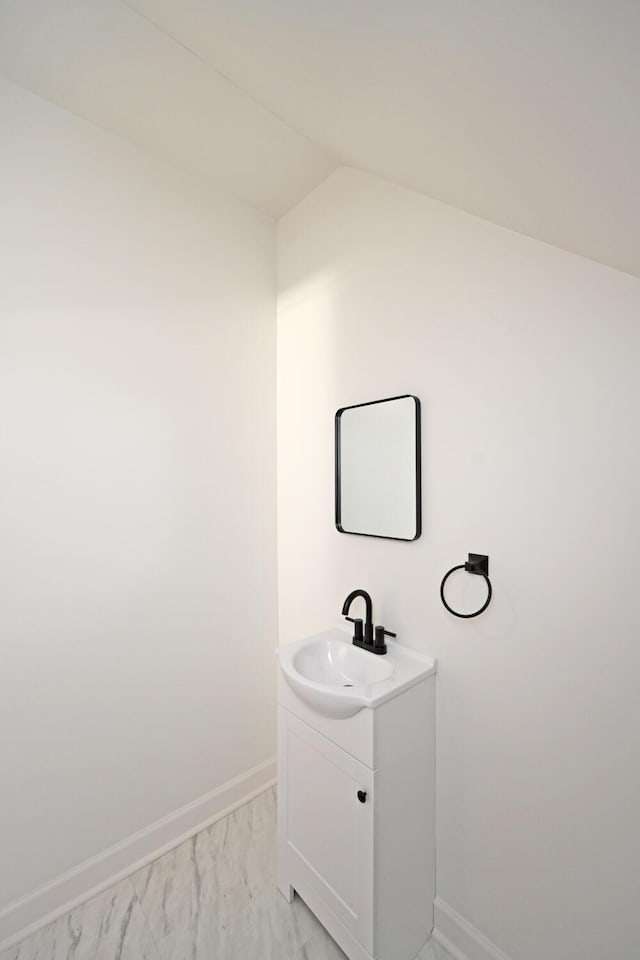 bathroom with vanity and vaulted ceiling