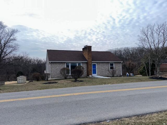 ranch-style house with a front lawn and a chimney