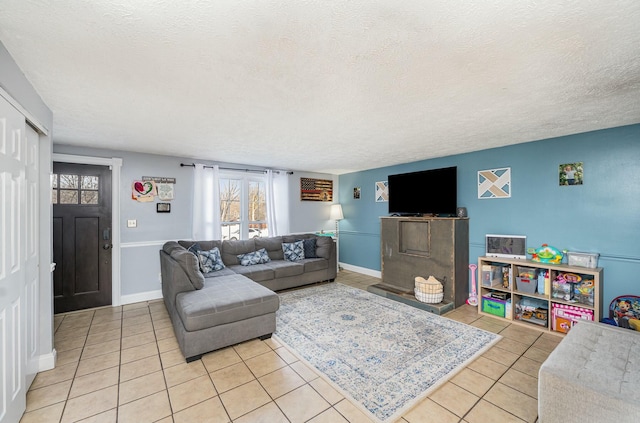 living area with a textured ceiling, baseboards, and light tile patterned floors