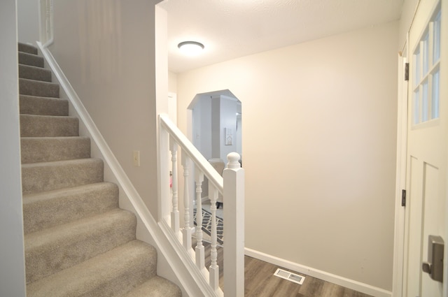 stairway featuring wood-type flooring