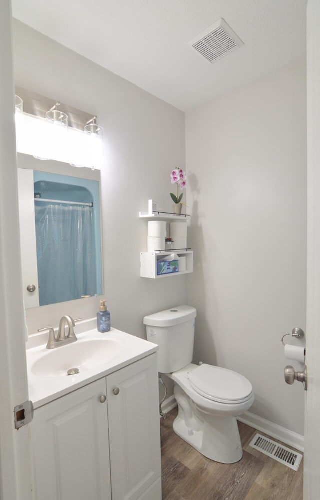 bathroom with wood-type flooring, toilet, a shower with shower curtain, and vanity