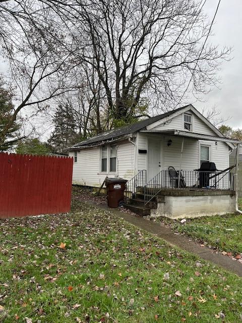 rear view of house with a yard and fence