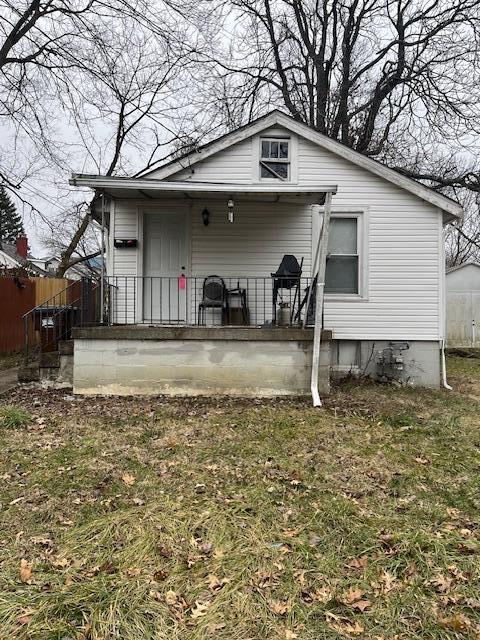 rear view of house featuring a yard and fence