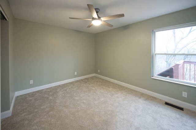 unfurnished room featuring light colored carpet and ceiling fan