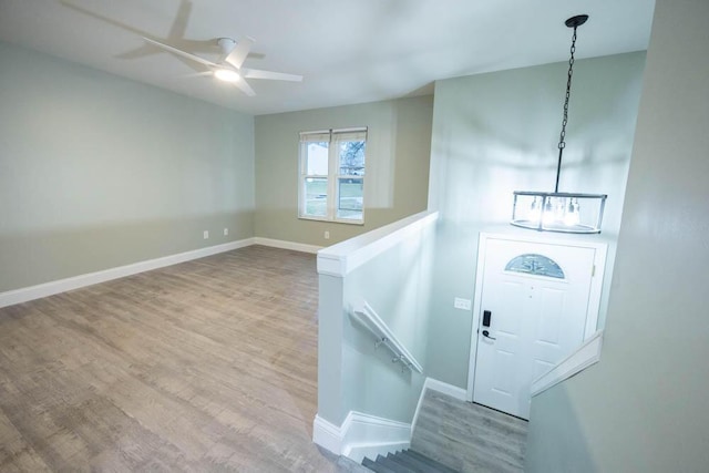 foyer featuring wood-type flooring and ceiling fan with notable chandelier