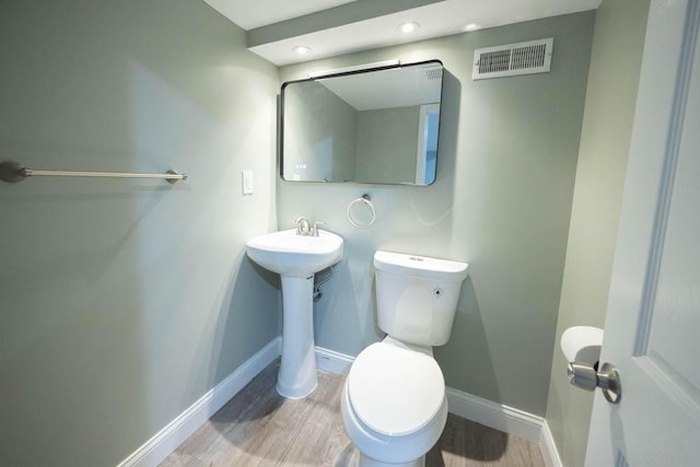 bathroom with wood-type flooring and toilet